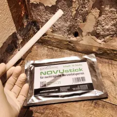 Ein Handschuh hält einen Stab für nachträgliche Horizontalsperren. Das Injektionsverfahren selber machen ist mit NOVUstick einfach.