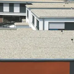 Mehrere moderne Gebäude mit verschiedenen **Flachdach Arten**, bedeckt mit Kies und mit sichtbaren Entlüftungsrohren.