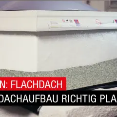Arbeiter dichtet eine Flachdachdurchdringung mit Bitumenbahnen ab. Der Aufbau des Flachdachs wird sorgfältig geplant.