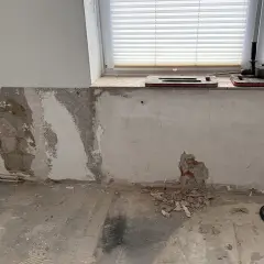Baustelle mit Werkzeug und freiliegendem Mauerwerk, das auf eine bevorstehende Verkieselung hindeutet.