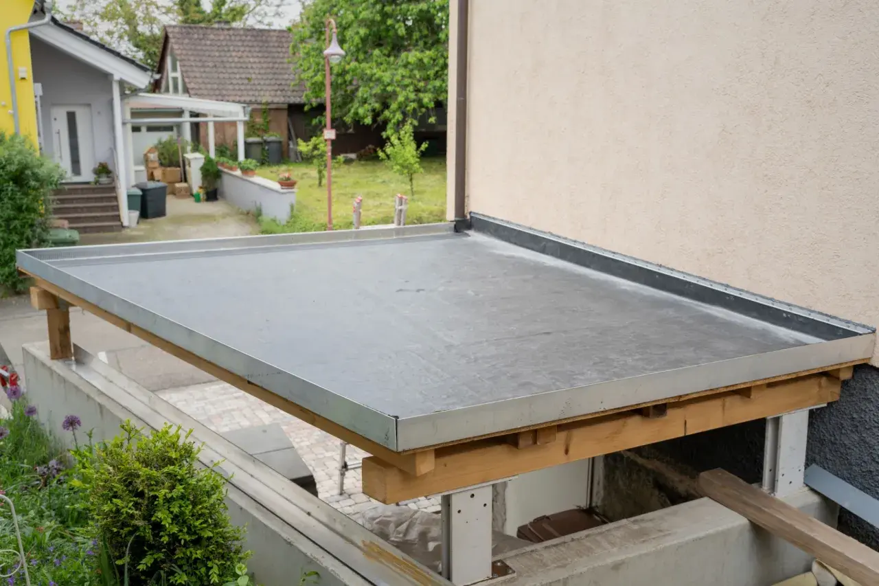 Neues Flachdach mit Folie abgedichtet. Die Unterkonstruktion aus Holz ist sichtbar.
